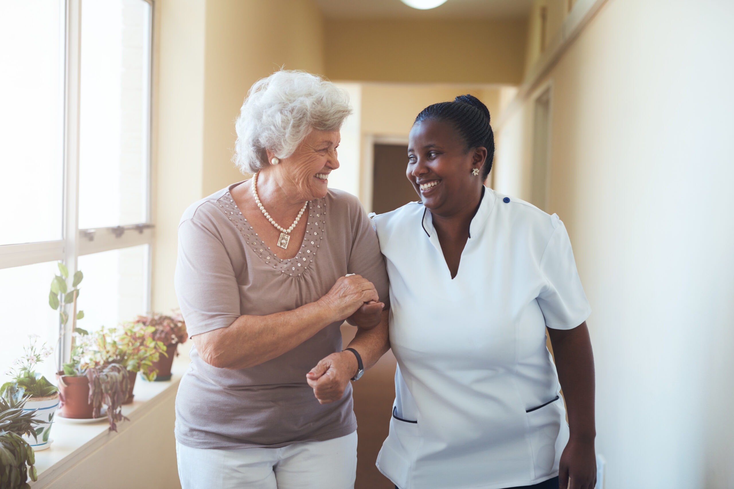 Caregiver supporting elderly woman